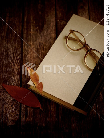 秋天和冬天讀書，木桌上的書、眼鏡和枯葉 118446719