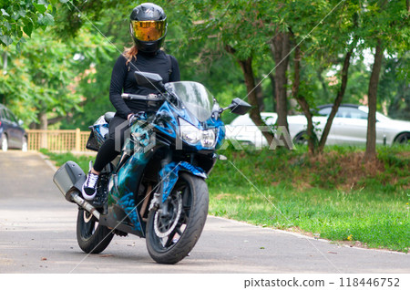 Biker girl sitting on her bike Biker girl sitting on her bike 118446752