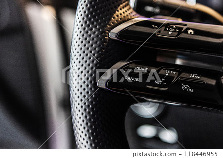 Close-up of a luxury car steering wheel featuring modern control buttons Close-up of a luxury car steering wheel featuring modern control buttons 118446955
