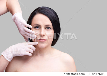 Aesthetic consultation: woman receiving facial examination by professional Aesthetic consultation: woman receiving facial examination by professional 118447608