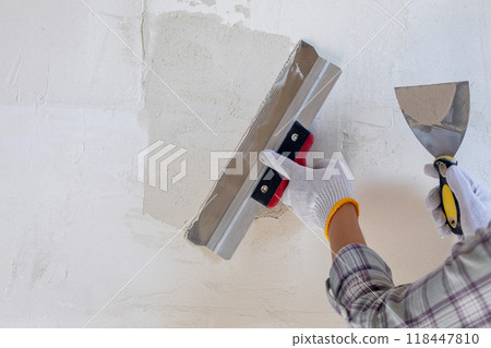 Concepts of puttying using a spatula on the wall. Concepts of puttying using a spatula on the wall. 118447810