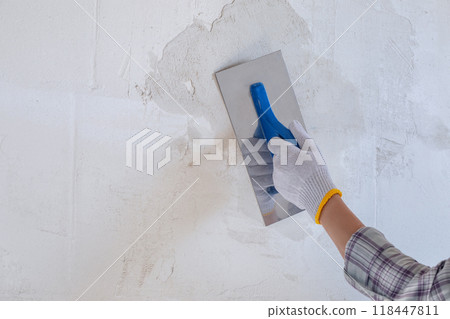 Plastering the wall using a trowel and starting plaster. 118447811