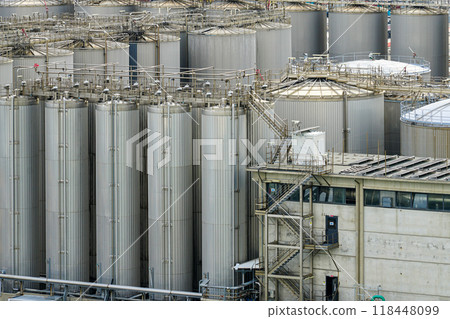 Many tall metal tanks in tank farm, high silos, multiple steel tanks to storage chemical products 118448099