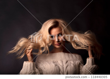 Studio photo portrait of a young pretty blonde on a dark background, close-up portrait of a woman Studio photo portrait of a young pretty blonde on a dark background, close-up portrait of a woman 118448305