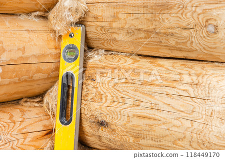 Yellow box beam level stands in the corner of new log house 118449170