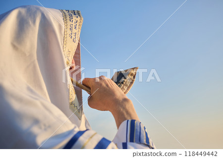Jewish man blowing the Shofar rams horn on Rosh Hashanah and Yom Kippur day. Jewish man blowing the Shofar rams horn on Rosh Hashanah and Yom Kippur day. 118449442