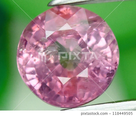 Exquisite Close-Up of a Sparkling Pink Gemstone on a Vibrant Green Background Exquisite Close-Up of a Sparkling Pink Gemstone on a Vibrant Green Background 118449505