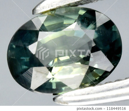 Captivating Teal Green Sapphire Gemstone in Precision Cut Displayed with Tweezers for Jewelry and Gemology Design Captivating Teal Green Sapphire Gemstone in Precision Cut Displayed with Tweezers for Jewelry and Gemology Design 118449516