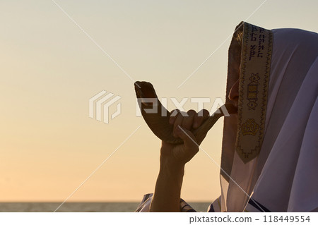 Jewish man blowing the Shofar rams horn on Rosh Hashanah and Yom Kippur day. Jewish man blowing the Shofar rams horn on Rosh Hashanah and Yom Kippur day. 118449554