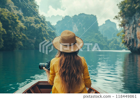Tranquil Lake Photography. A person with a backpack and hat enjoys a tranquil boat ride 118449861