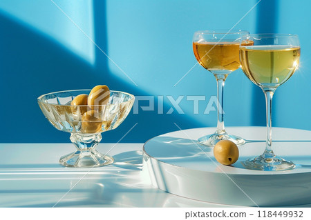 Elegant Aperitif Scene. Two elegant glasses of amber liquid next to a bowl of green olives 118449932