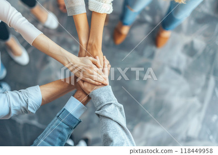 Teamwork Unity. Six individuals placing their hands together in a gesture of unity and teamwork. 118449958