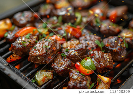 Grilled Kabobs Closeup. Sizzling grilled kabobs with veggies and herbs on a grill pan 118450209