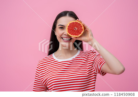 Pretty happy young woman in striped tshirt with part of grapefruit in hand Pretty happy young woman in striped tshirt with part of grapefruit in hand 118450908