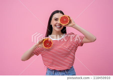 Pretty happy young woman in striped tshirt with part of grapefruit in hand 118450910