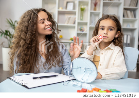 Child and doctor working on articulation and looking contented and concentrated 118451019