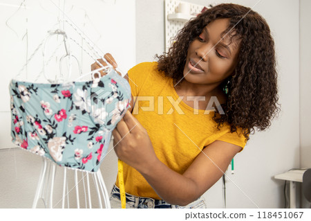 Fashion designer working on new models in her studio and looking involved 118451067