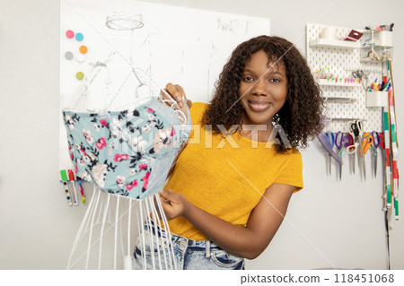 Fashion designer working on new models in her studio and looking involved Fashion designer working on new models in her studio and looking involved 118451068