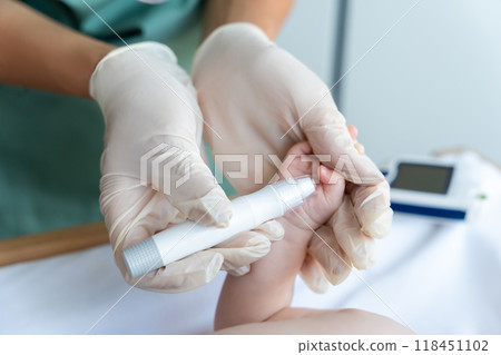 Nurse using glucometer on newborn baby to check his level of sugar in blood 118451102