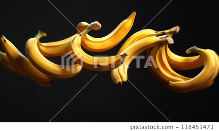 Bananas are elegantly suspended in mid-air, creating a striking visual against a dark background. Their yellow curves swirl in a harmonious dance, drawing the eye and inspiring delight 118451471