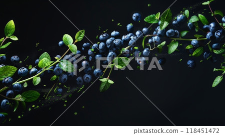 Fresh blueberries are artfully arranged with lush green leaves, creating a stunning visual against a dark backdrop that highlights their rich colors 118451472