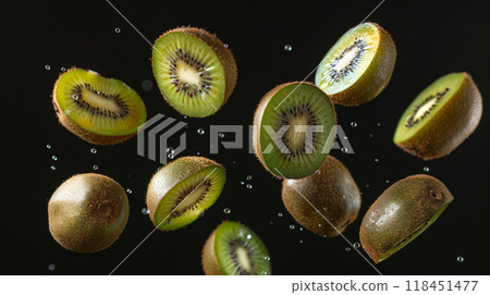 Floating kiwi slices showcase their vibrant green flesh and unique texture against a dark backdrop, creating a visually striking display of fresh fruit 118451477