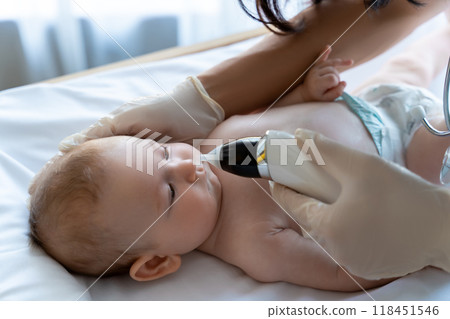 Unrecognizable doctor in medical gloves checking nose of baby girl or boy Unrecognizable doctor in medical gloves checking nose of baby girl or boy 118451546