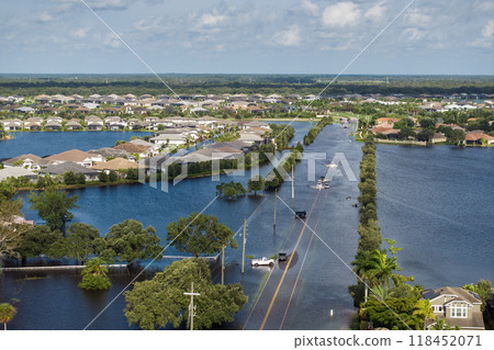 Flooded Florida street with stuck car after hurricane Debby rainfall surrounded with water. Consequences of natural disaster Flooded Florida street with stuck car after hurricane Debby rainfall surrounded with water. Consequences of natural disaster 118452071