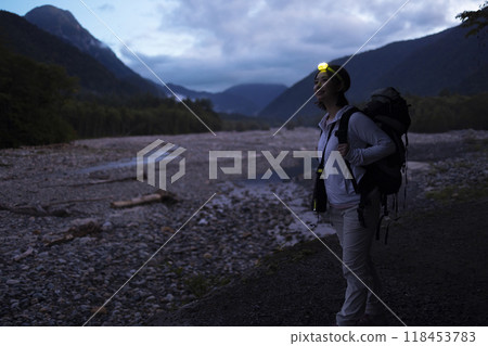 Woman climbing a mountain with a headlamp Woman climbing a mountain with a headlamp 118453783