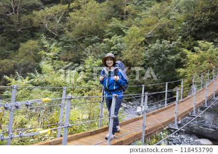 Mountain girl crossing a suspension bridge 118453790