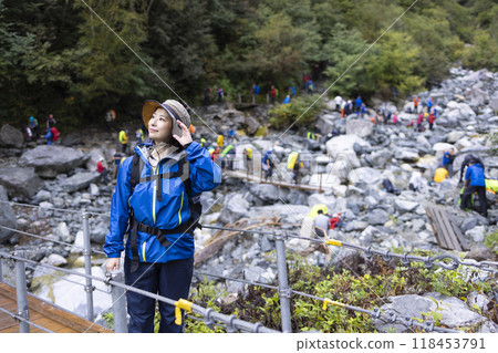 Mountain girl crossing a suspension bridge 118453791
