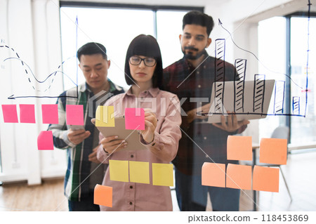 Team brainstorming session with sticky notes and graphs 118453869