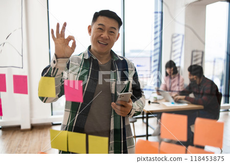 Smiling man in casual office brainstorming session Smiling man in casual office brainstorming session 118453875