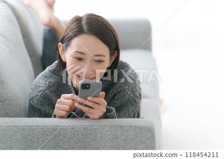 使用智能手機的婦女在沙發 118454211