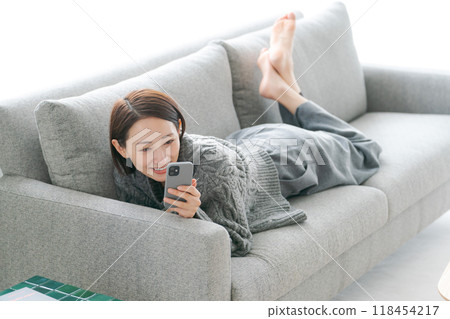 使用智能手機的婦女在沙發 118454217