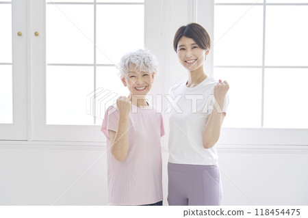 Elderly and middle-aged women wearing sportswear posing with fist pumps Elderly and middle-aged women wearing sportswear posing with fist pumps 118454475
