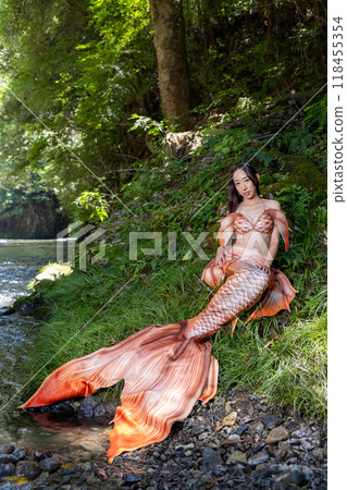 A black-haired female mermaid sitting by the river A black-haired female mermaid sitting by the river 118455354