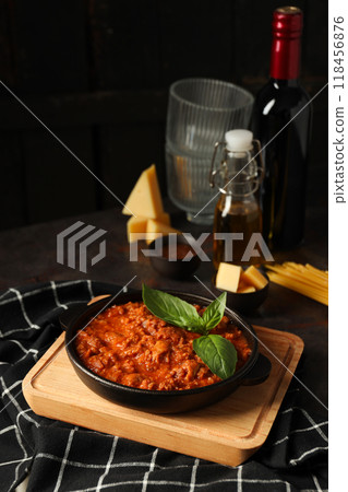 Bolognese sauce, glasses, bottle of wine and pieces of cheese on dark background Bolognese sauce, glasses, bottle of wine and pieces of cheese on dark background 118456876