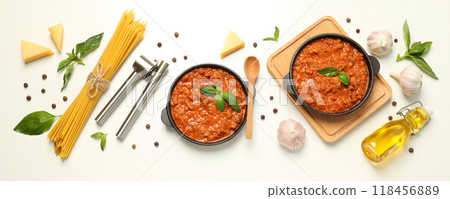 Pans with Bolognese sauce, spaghetti and ingredients on white background, top view Pans with Bolognese sauce, spaghetti and ingredients on white background, top view 118456889
