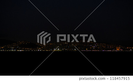 The vibrant lights of Istanbul twinkle against the dark sky, reflecting on the water as the city comes alive after sunset. 118457915