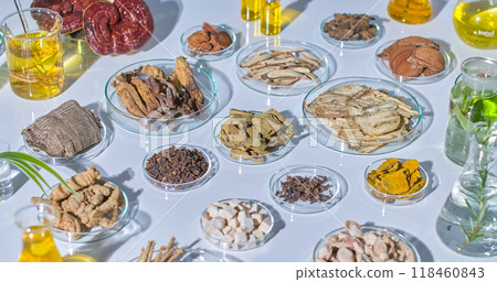 Sample photographs for laboratory studies with laboratory settings features a table filled with various herbs, roots, and lab equipment showcases the diversity of natural ingredients used in research. 118460843