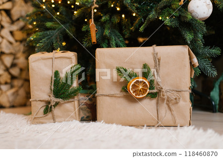 Brown boxes gifts with orange decorations under christmas tree Brown boxes gifts with orange decorations under christmas tree 118460870