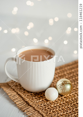 A white cup with hot coffee or tea on a white wooden table. A white cup with hot coffee or tea on a white wooden table. 118461219