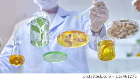 Bottom view shows a scientist dripping gold extract from a straw into a petri dish containing turmeric and a solution next to other herbs. Sample photo for laboratory 118461276
