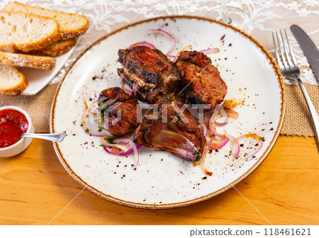 There is plate with cooked lamb barbecue shashlik on wooden table. Pieces of lamb fried on open fire 118461621