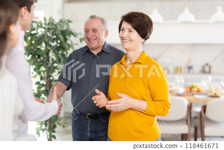 Elderly parents with open arms greeting son with wife at home Elderly parents with open arms greeting son with wife at home 118461671