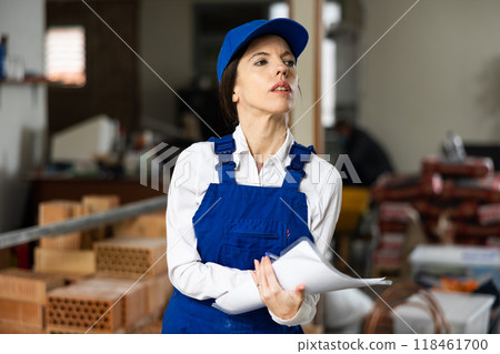 Female foreman making task list during works in building under construction Female foreman making task list during works in building under construction 118461700