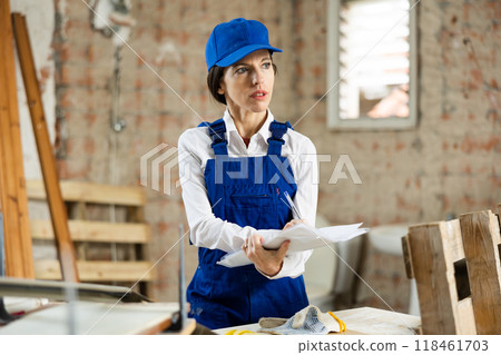 Female contractor taking notes while planning building renovation Female contractor taking notes while planning building renovation 118461703