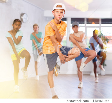 Expressive tween boy practicing hip-hop movements during group dance class 118461946