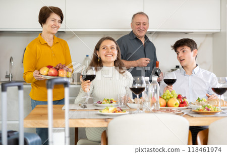 Cheerful parents meeting young couple at home. Happy adult son and his wife guest at family table Cheerful parents meeting young couple at home. Happy adult son and his wife guest at family table 118461974